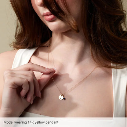 Initial disc necklace worn on model