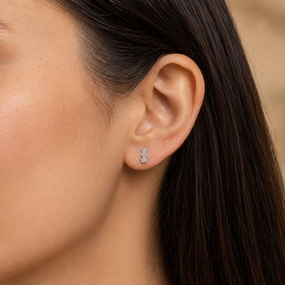 Petite white-gold three-diamond ear climber shown at its true scale on the ear