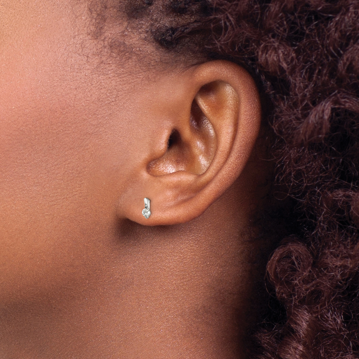 Petite sterling silver CZ drop-effect stud earrings worn on ear